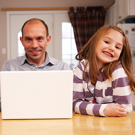 Illustrasjonsfoto: Far og barn bruker PC på kjøkkenet